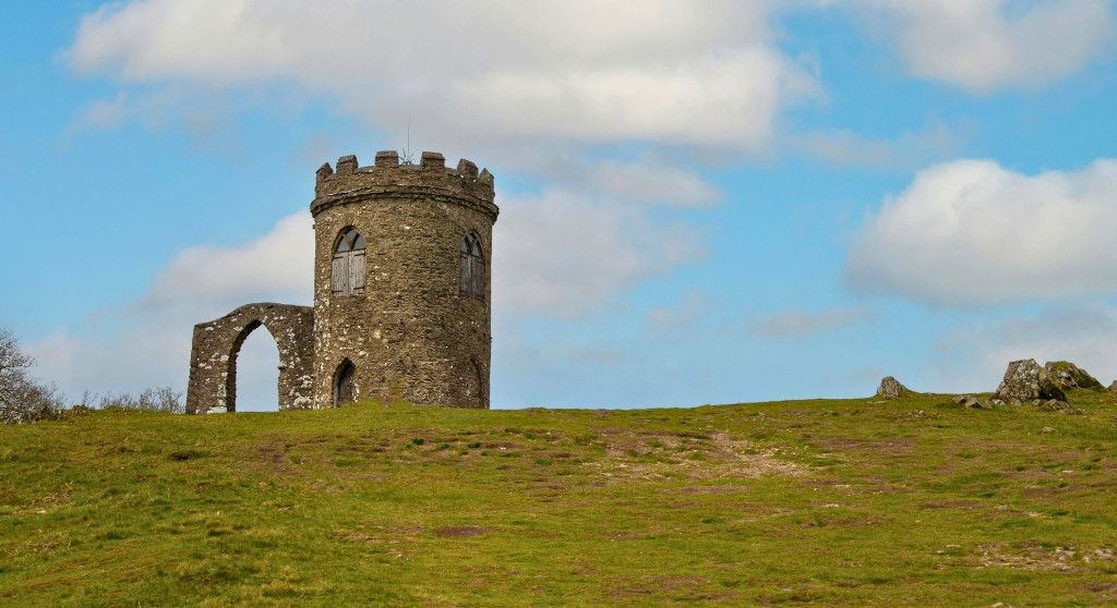 Old John Tower on the hill at Bradgate Park, Leicestershire, under a blue sky with white clouds.